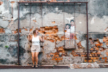 Julia auf einer Schaukel und Streetart in George Town Malaysia