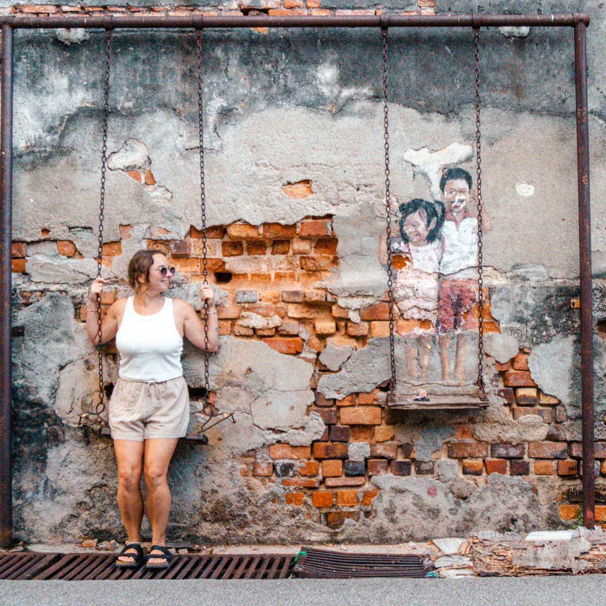 Julia auf einer Schaukel und Streetart in George Town Malaysia