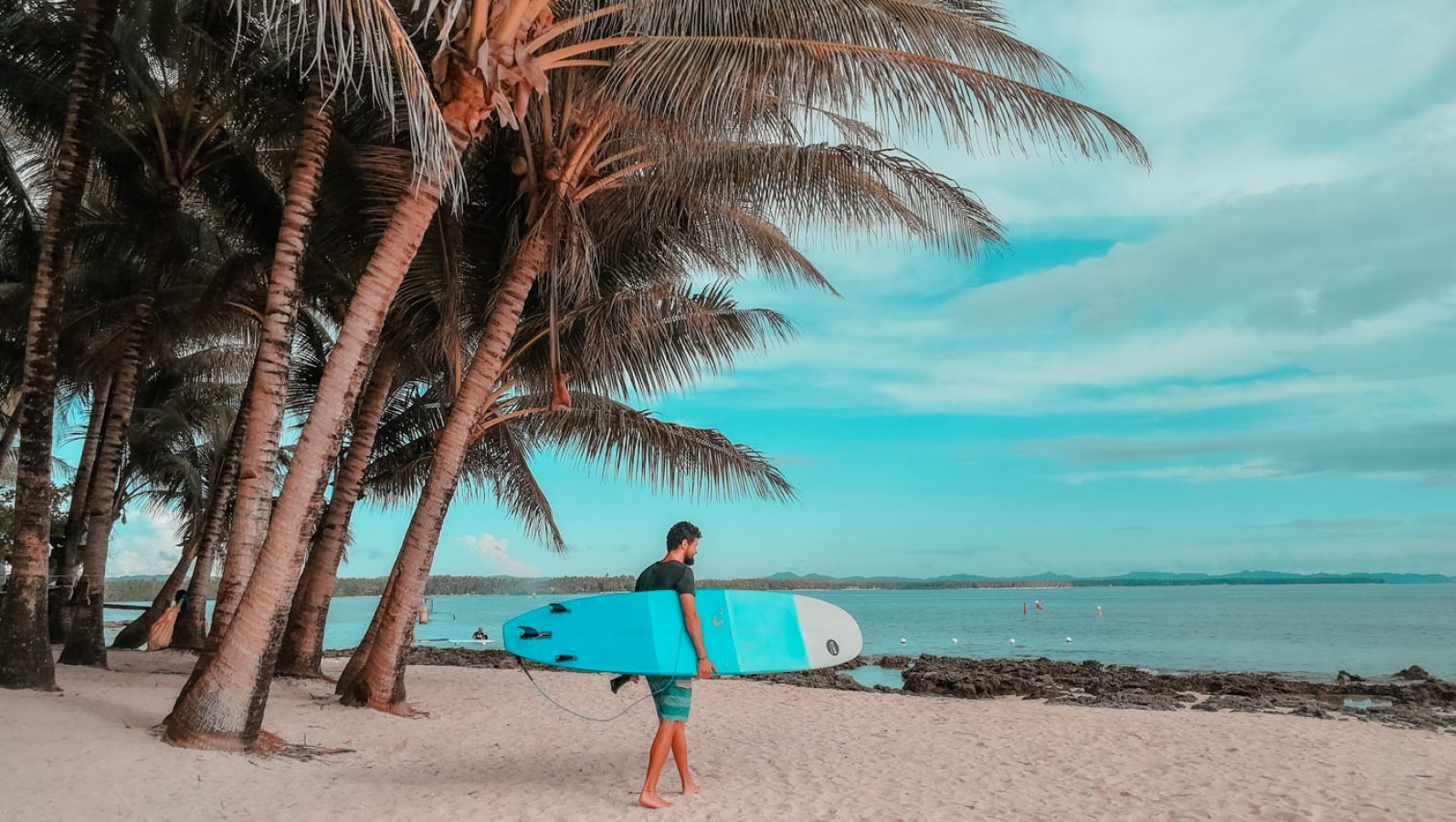 Matthias mit dem Surfbrett am Strand