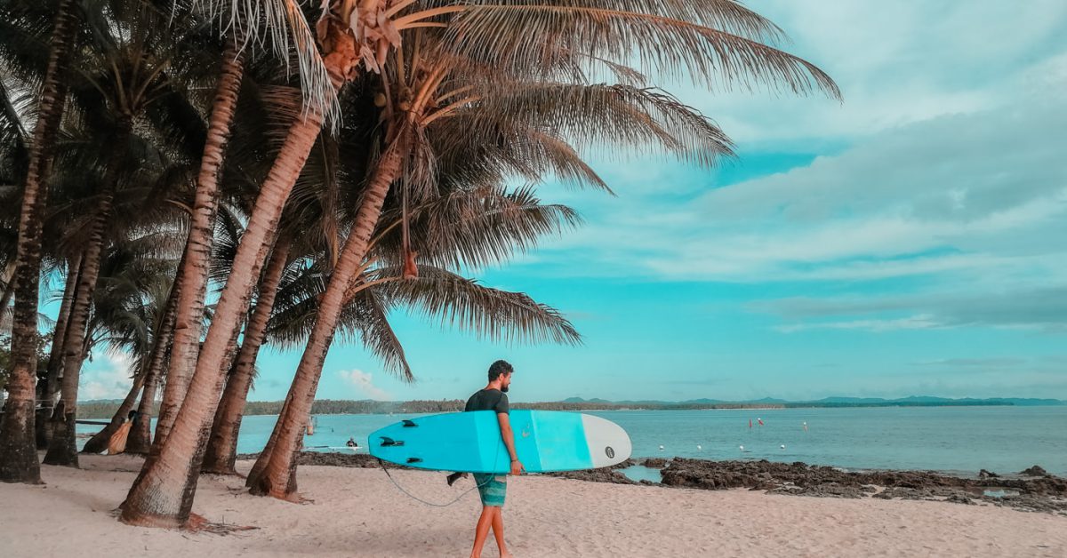 Matthias mit dem Surfbrett am Strand