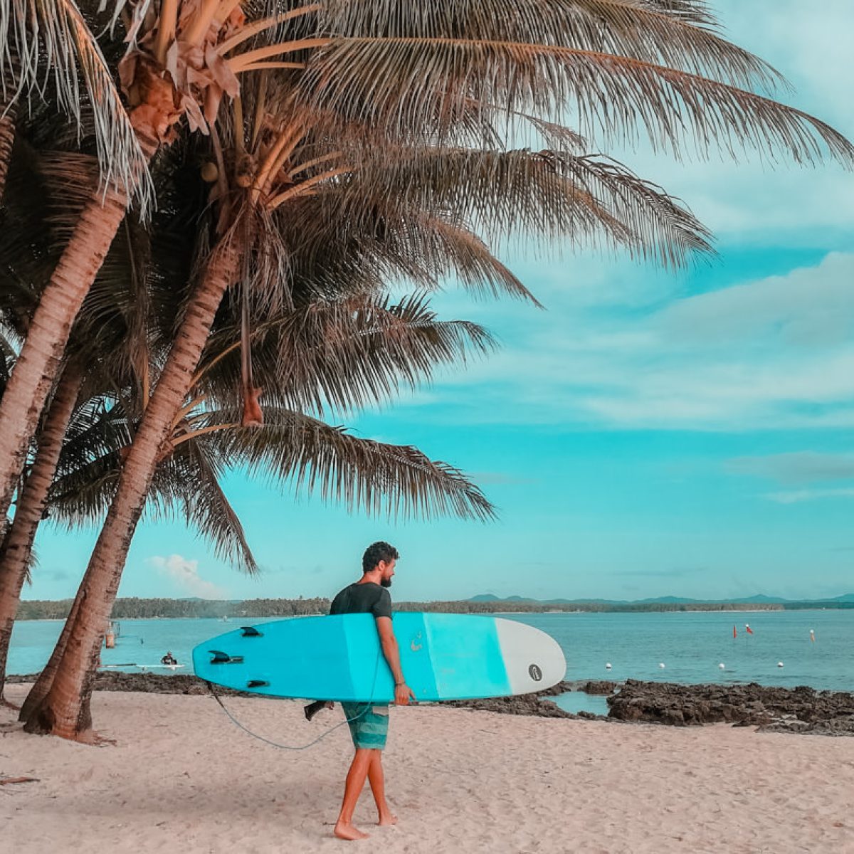 Matthias mit dem Surfbrett am Strand